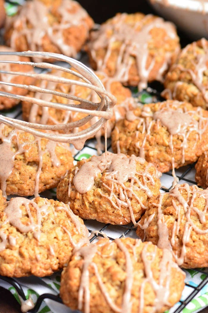  Cinnamon Oatmeal Cookies on a cooling rack with frosting on top 