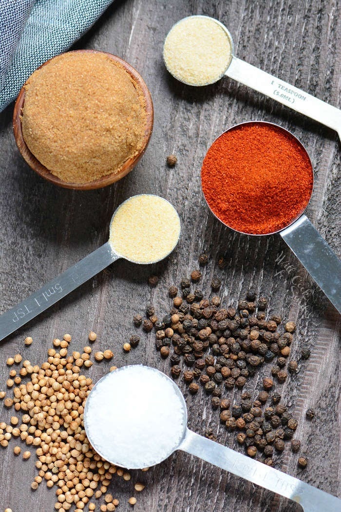 measuring spoons full of the spices for dry rub on a cutting board 