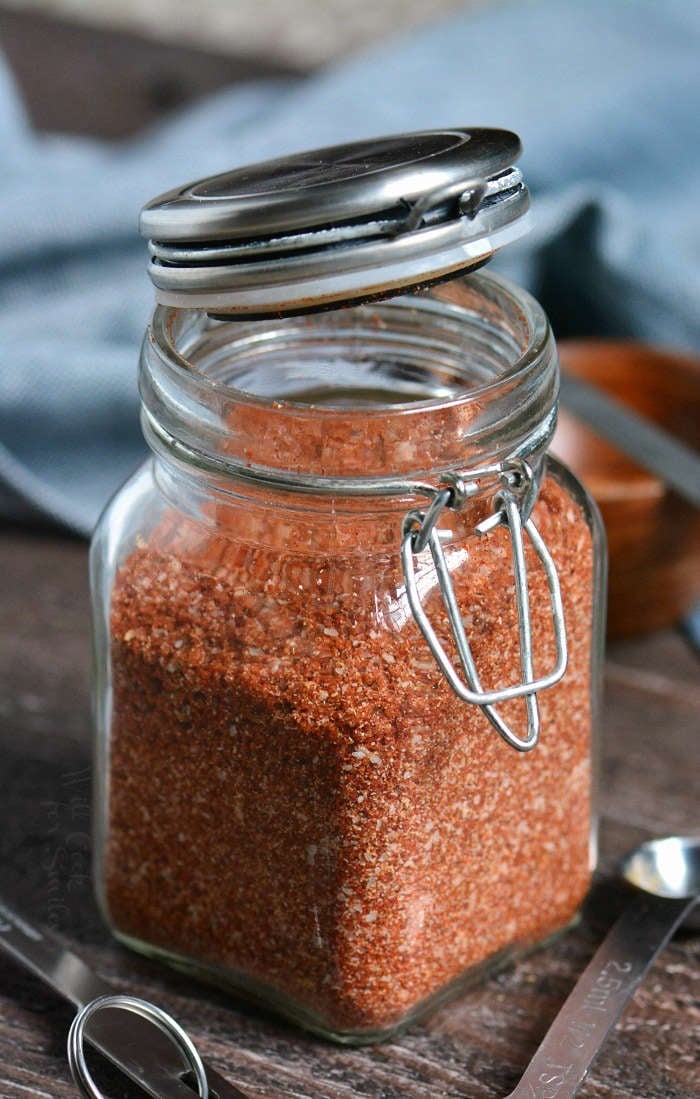 The Ultimate Dry Rub recipe in a jar on a wooden cutting board 