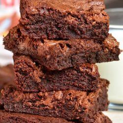 five brownies stacked up on a piece of parchment paper.