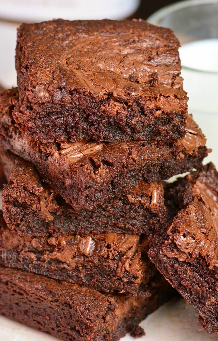 nutulla brownies stacked up on a white plate.