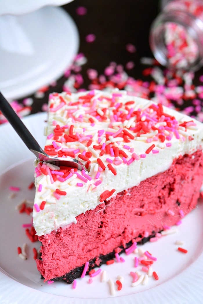 Red Velvet Cheesecake. This luscious cheesecake is inspired by a traditional red velvet cake and made with buttermilk, vinegar, cocoa powder, and topped with cream cheese frosting. #cheesecake #redvelvet #dessert #frosting 