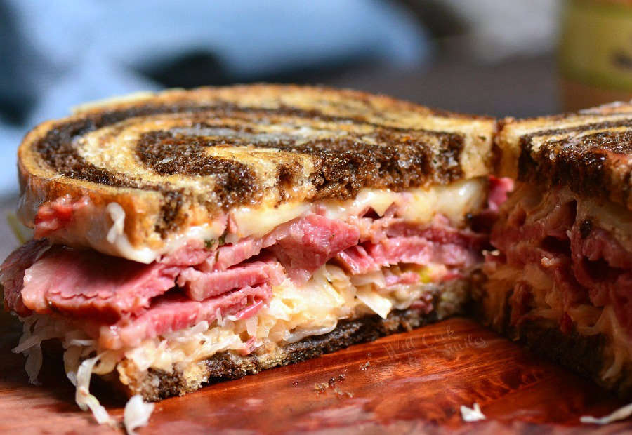 Reuben Sandwich cut in half in cutting board 