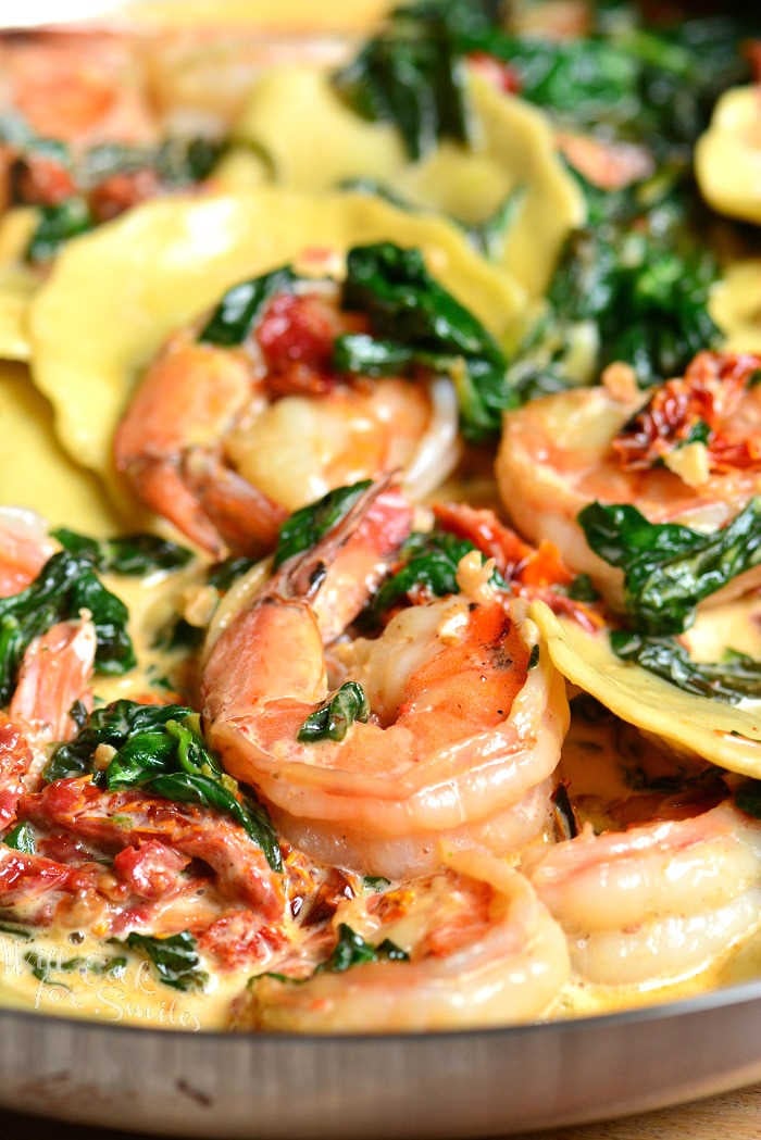Creamy Tuscan Shrimp Ravioli. Easy and comforting dinner that takes less than 30 minutes to prepare. Juicy shrimp is cooked with garlic, spinach, sun-dried tomatoes, and cream. #shrimp #ravioli #dinner #seafood #easydinner #30minute