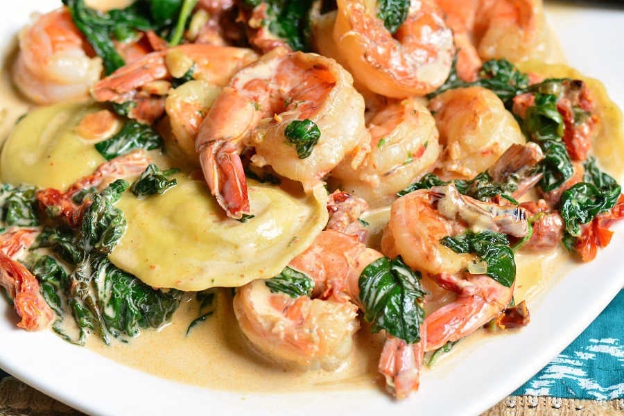 Creamy Tuscan Shrimp Ravioli. Easy and comforting dinner that takes less than 30 minutes to prepare. Juicy shrimp is cooked with garlic, spinach, sun-dried tomatoes, and cream. #shrimp #ravioli #dinner #seafood #easydinner #30minute