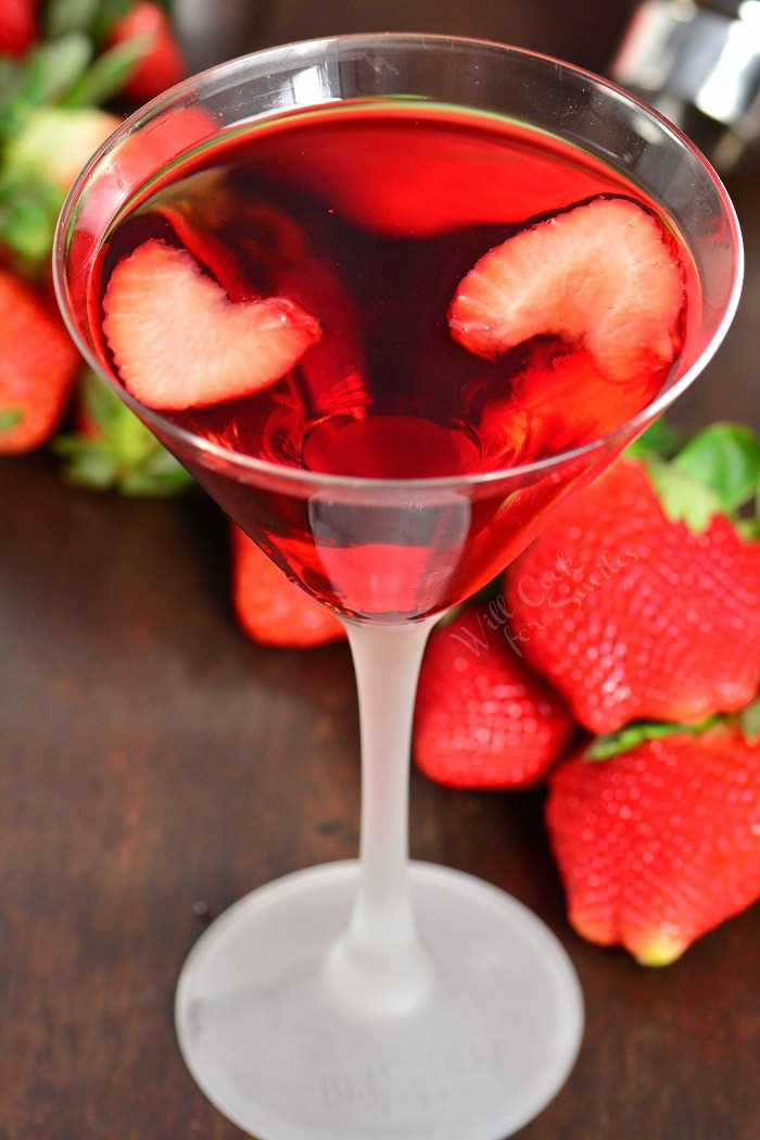 Strawberry Shortcake Martini in a glass on a wood table with strawberries 