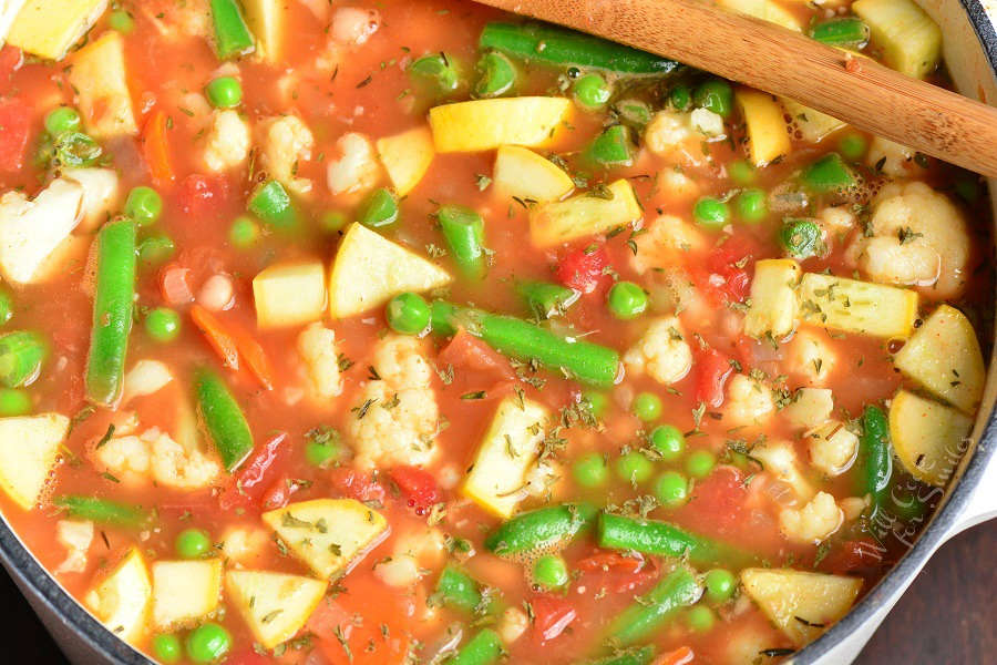 Vegetable Soup in a stock pot with wooden spoon 