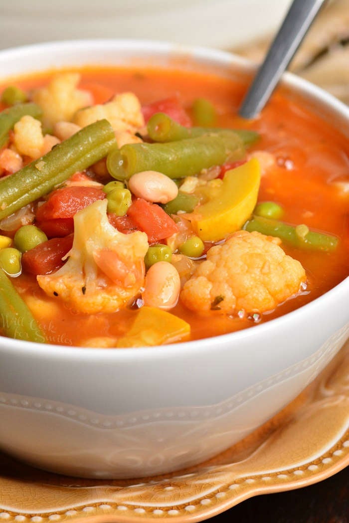 Vegetable Soup in a bowl with a spoon on a yellow plate 