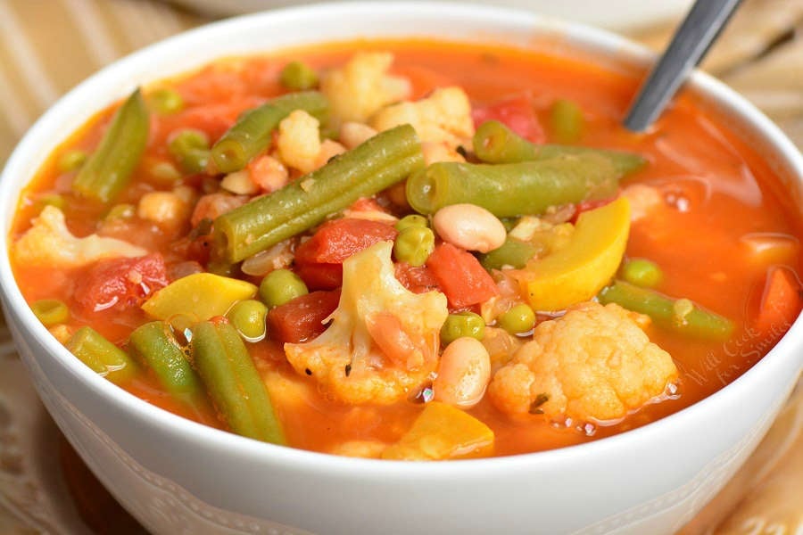 soup in a bowl with spoon on a cutting board 