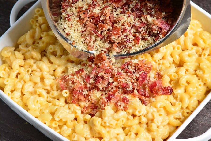 Baked Mac and Cheese in a casserole dish pourung bread crumbs with Bacon over the top. 