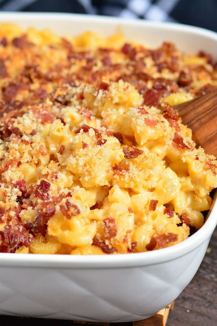 Baked Mac and Cheese in a casserole dish with a wooden spoon 