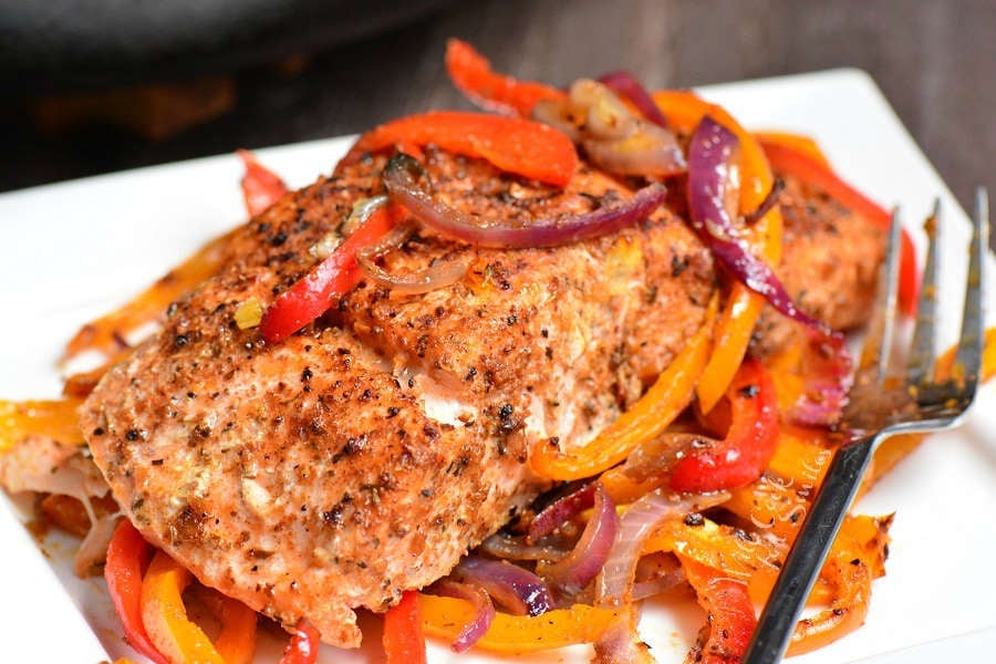 cajun baked salmon on a white plate with a fork 