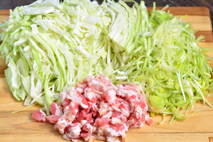 ingredients to make fried cabbage on cutting board.