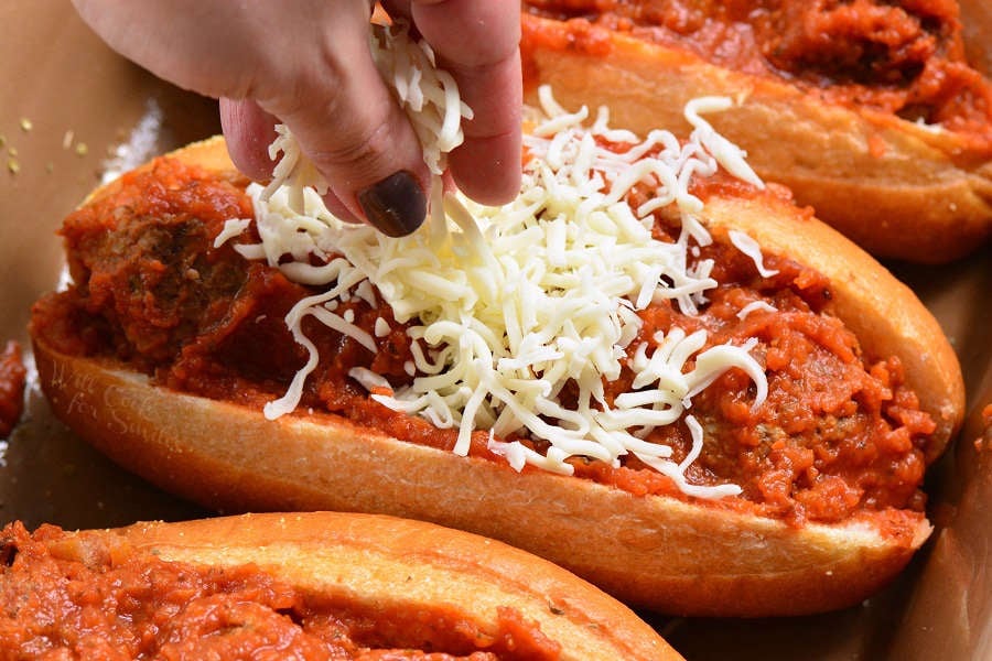 putting cheese over meatballs subs that are in a casserole dish 