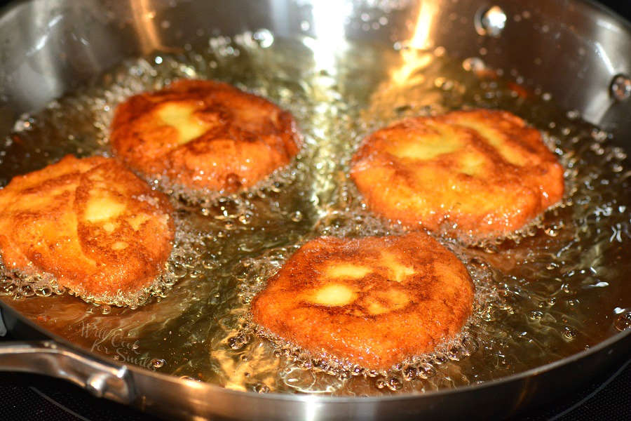 potato pancakes being fried in a pan of oil.