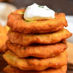 stack of potato pancakes on a wood cutting board.