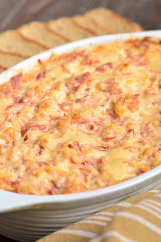 side view on baked reuben dip in a white baking dish.