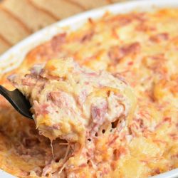 scooping out some Reuben dip with a spoon.
