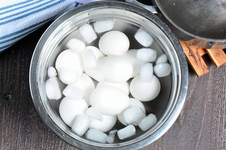hard boiled eggs in a ice bath in a metal bowl 