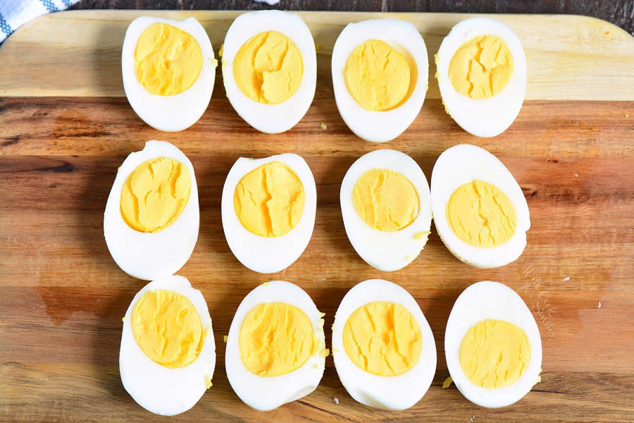 hard boiled eggs cut in half on wood cutting board 