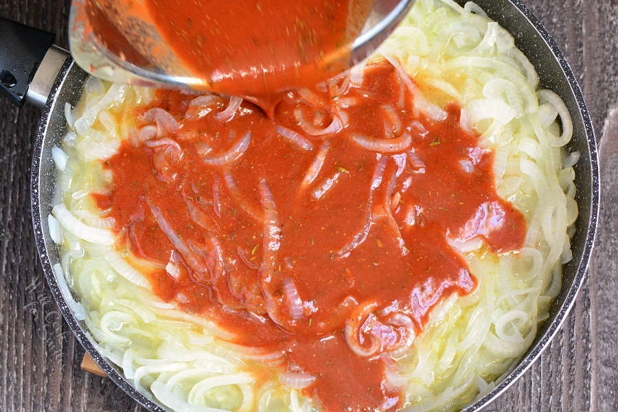 pouring sauce into onions that are in a pan 