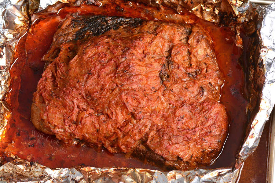 cooked beef brisket in a tin foil lined baking dish