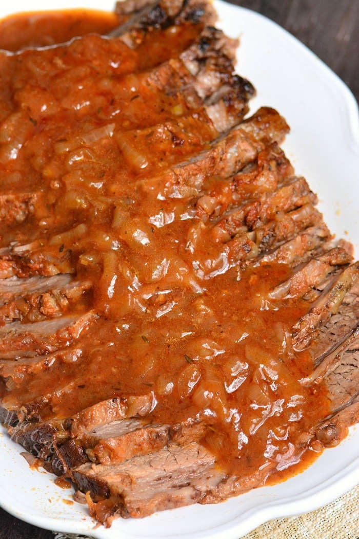 French Onion Beef Brisket sliced with French Onion gravy on a white serving platter