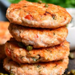 four salmon patties are stacked on top of each other.