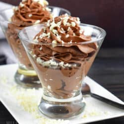 swirled chocolate mousse in a clear glass with shaved white chocolate on top.