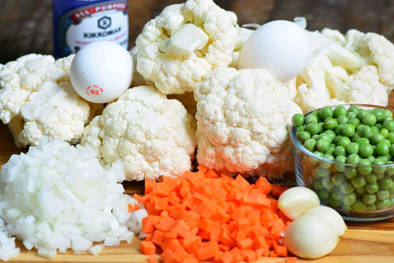 Ingredients for cauliflower fried rice on a wood cutting board 