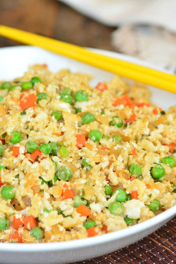 Cauliflower Fried Rice in a bowl with chop sticks 