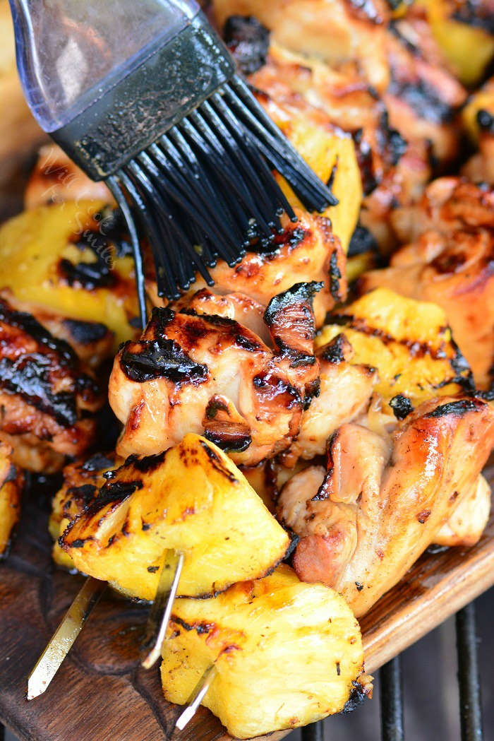Pineapple Chicken kebabs being brushed with marinade 