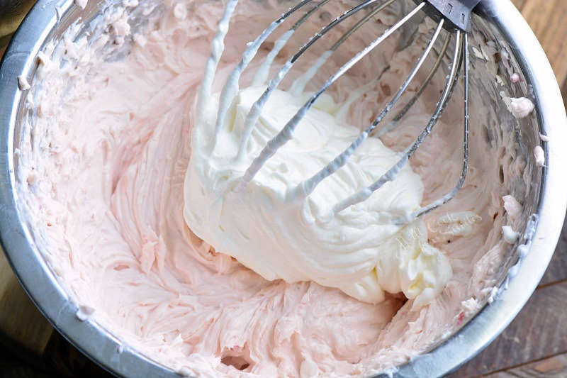 No bake cheesecake filling in a metal bowl with a whisk