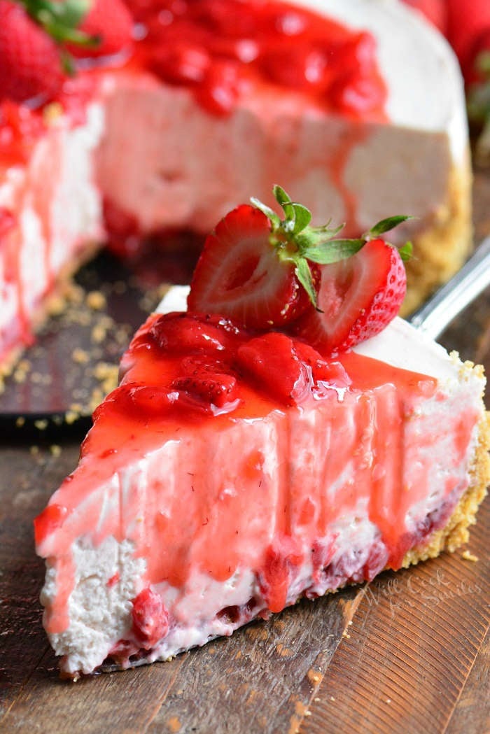 Strawberry No Bake Cheesecake slice on a wood cutting board 