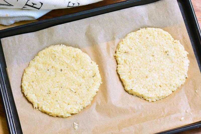 cauliflower grilled cheese pieces uncooked on parchment paper on a baking sheet 