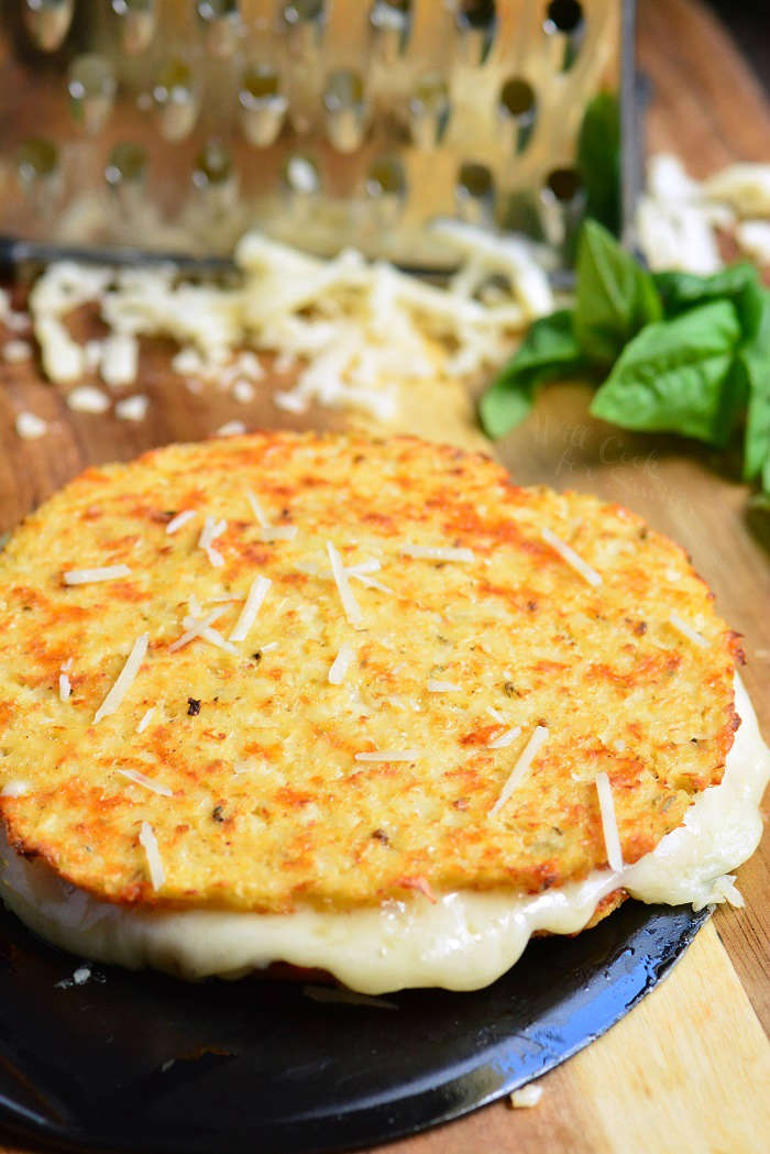 Cauliflower grilled cheese mozzarella and cheddar on a cutting board with a cheese grater 