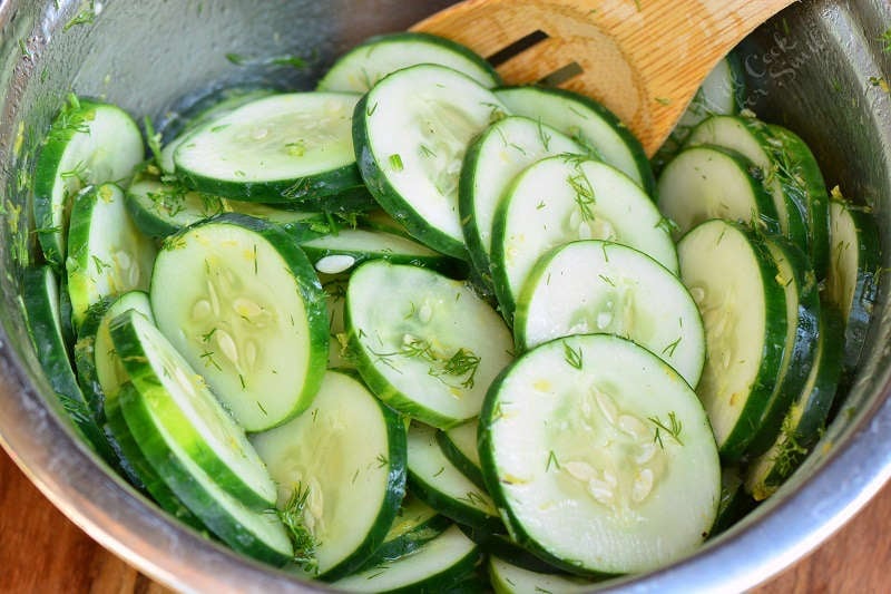 mix cucumbers and the dressing in a metal bowl with a wooden spoon 
