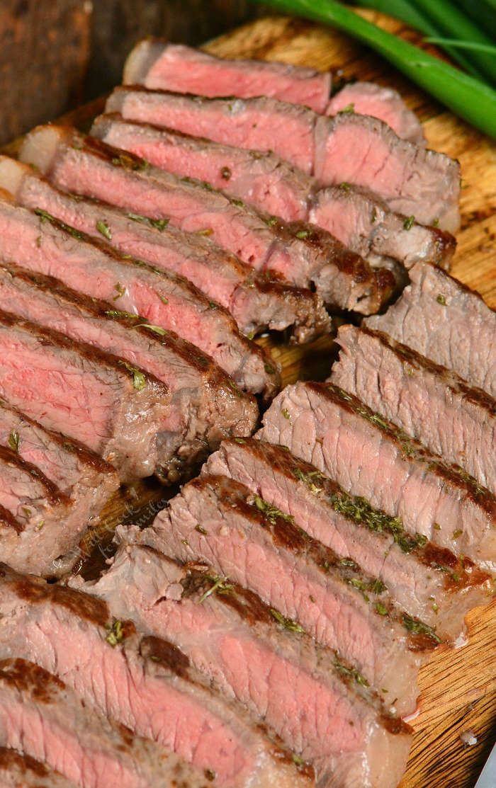 Sliced srtip steaks on wooden board