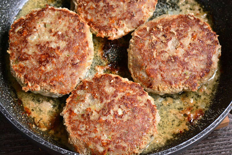 turkey burgers cooking in a pan 