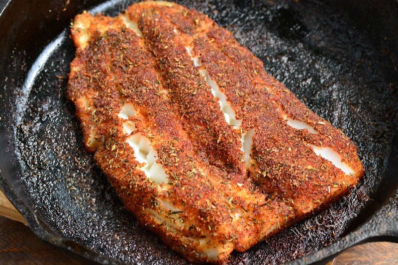 cooked blackened fish filet on a cooking pan.