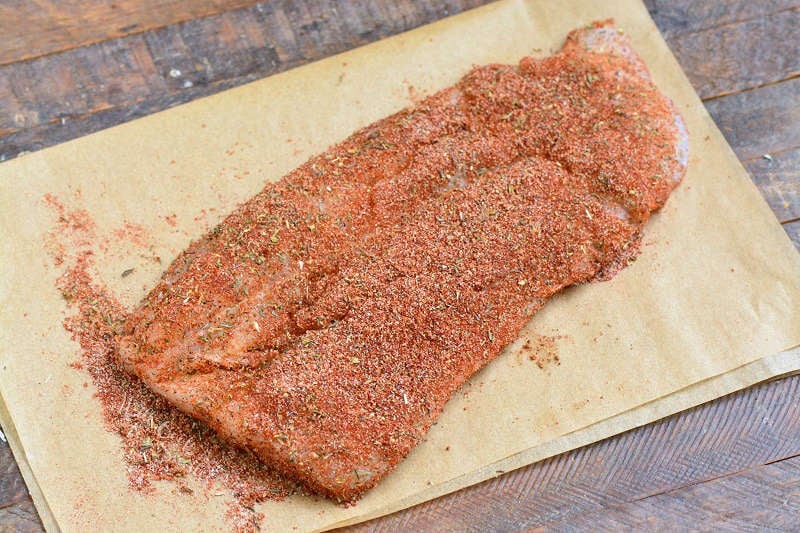 filet of fish coated in blackening seasoning on parchment paper.