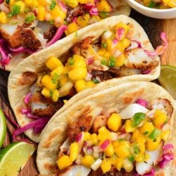 three soft tortillas filled with blackened flaked fish, cabbage, and mango salsa.