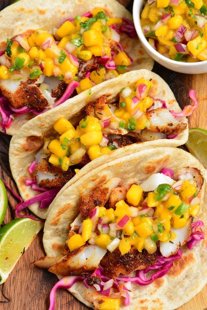 three soft tortillas filled with blackened flaked fish, cabbage, and mango salsa.
