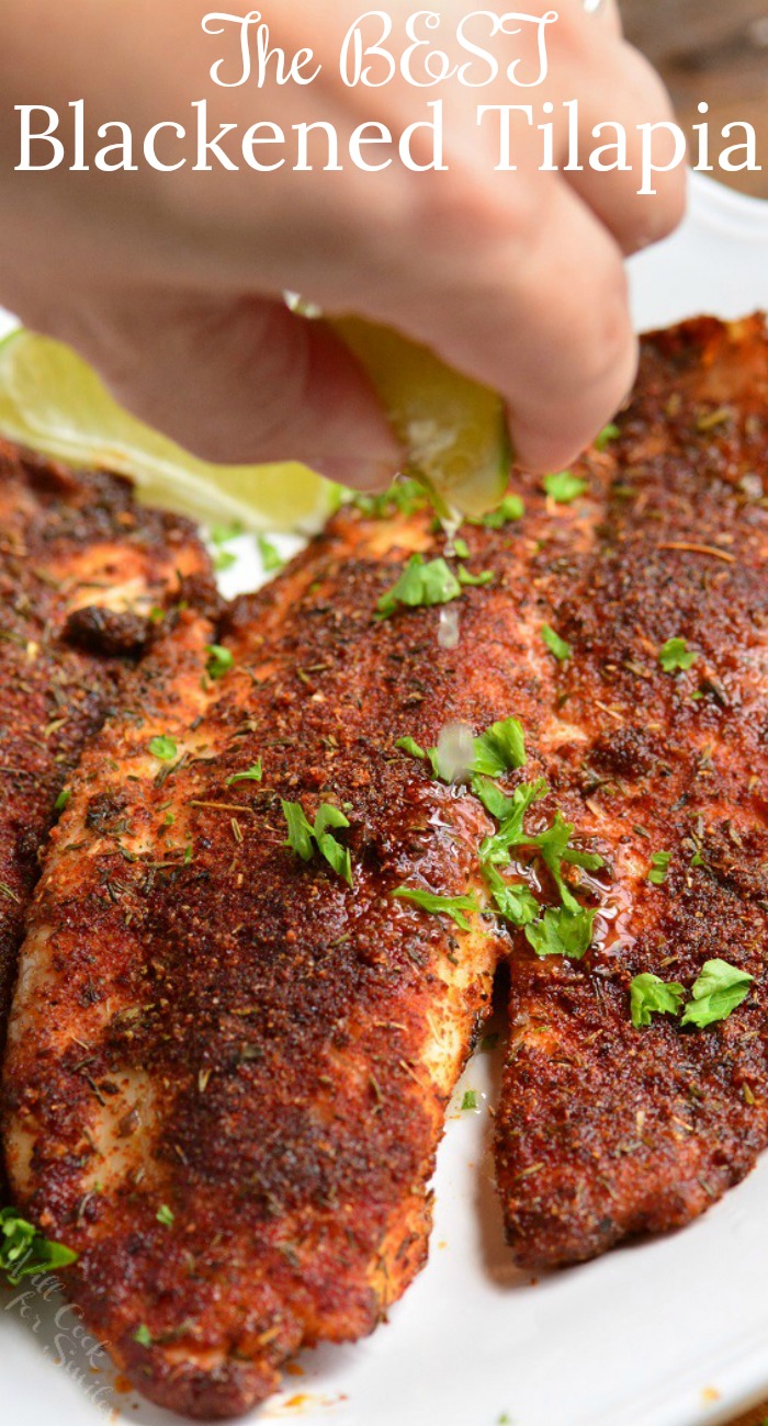 Blackened fish on a plate with lime being squeezed over 