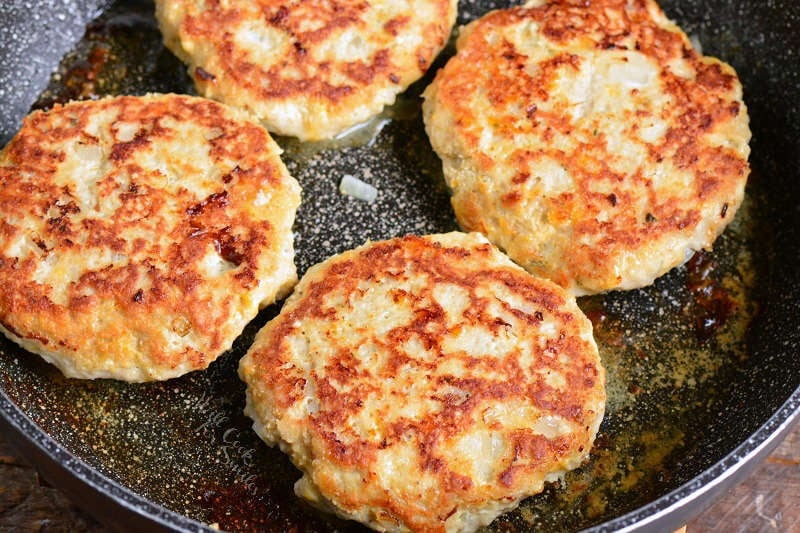chicken burgers on stovetop in a frying pan