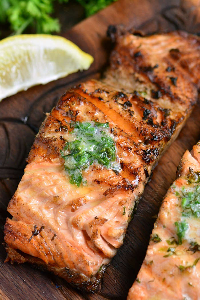 easy grilled salmon with herb butter on a wooden board with a lemon 