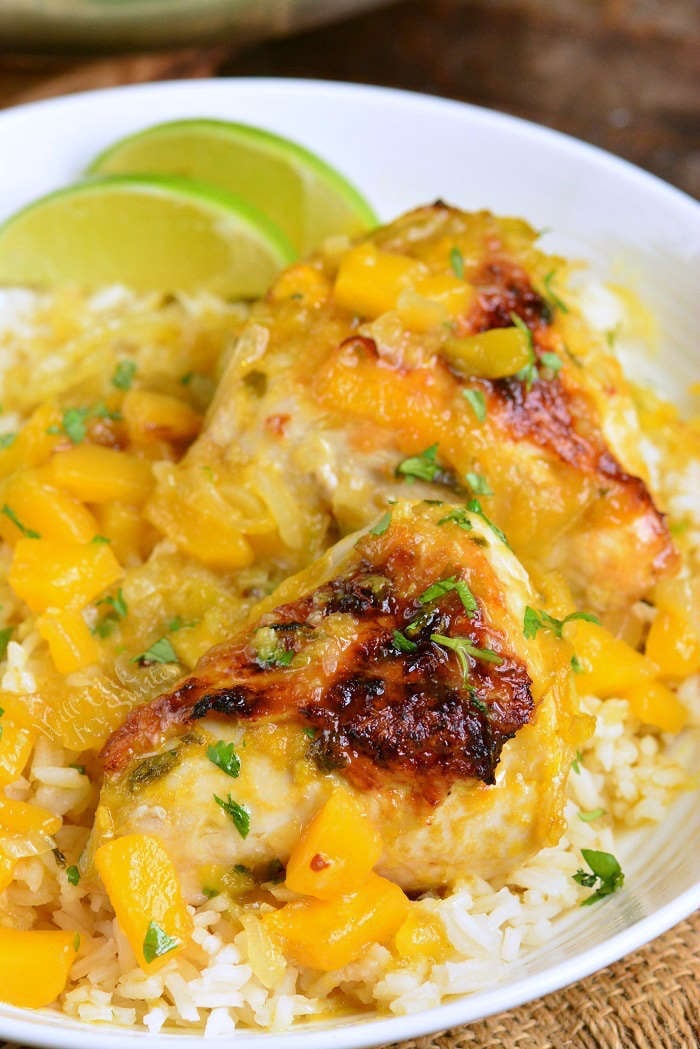 mango chicken and rice on a plate with lime wedges 