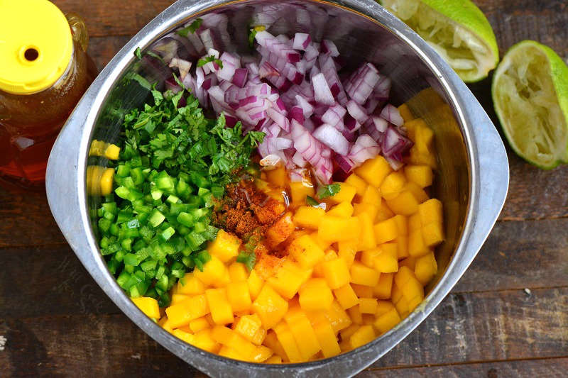 ingredients for mango salsa in a metal bowl.