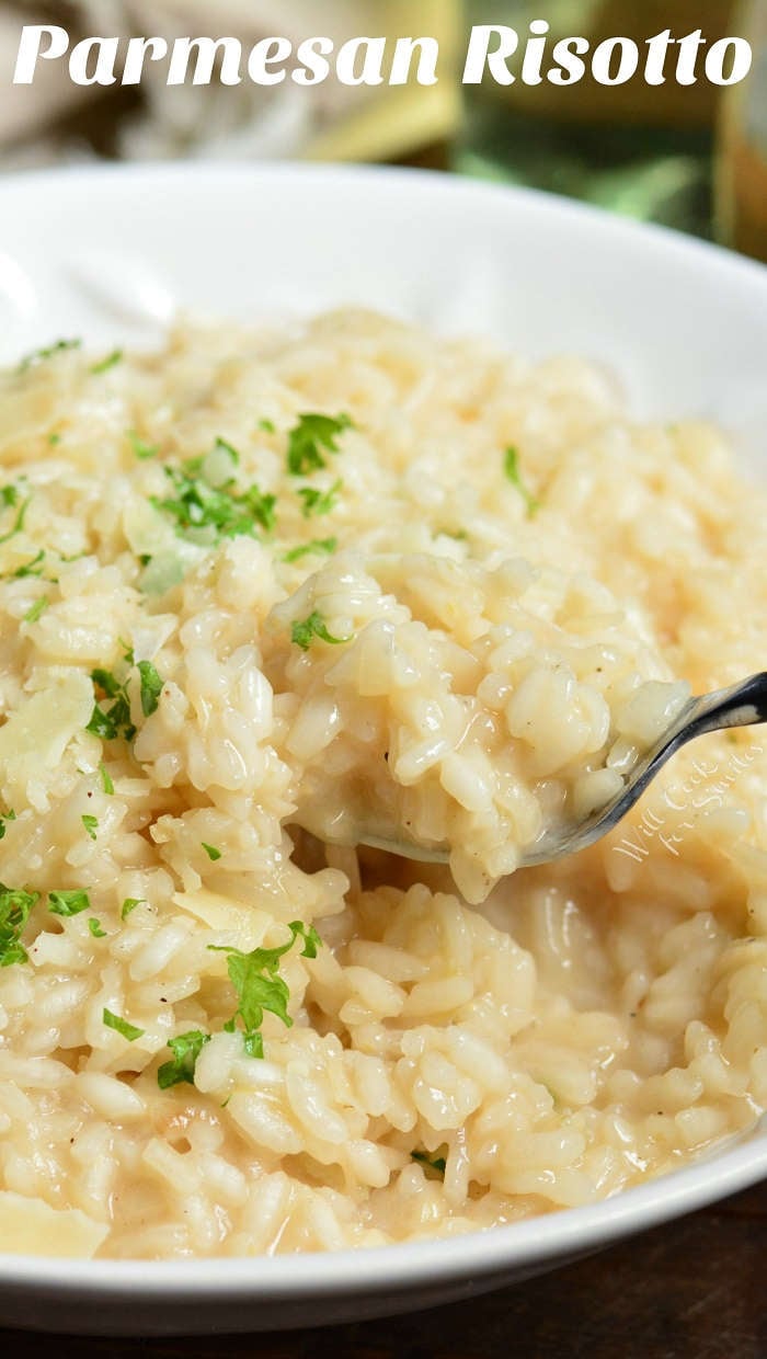 Risotto in a bowl being scooped out by a spoon 