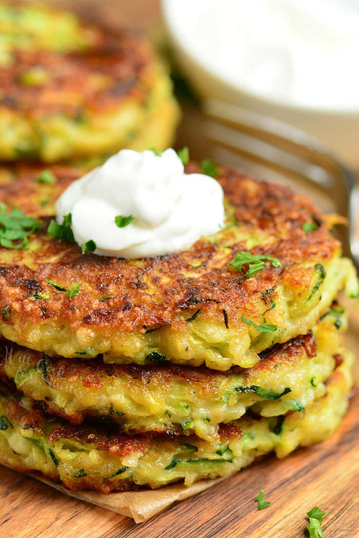 serve zucchini critters with sour cream on a wood cutting board 
